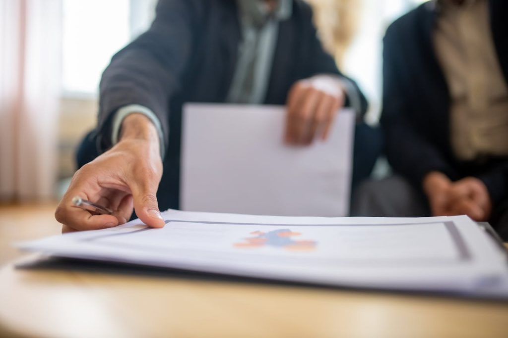 pexels-photo-8439663 Close-up of a businessman reviewing important documents at a desk in an office setting.